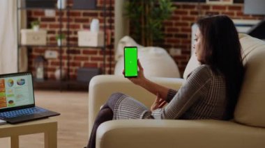 Piyasa performans grafiklerini optimize ederken izole edilmiş cep telefonuna bakan uzaktan çalışan. Online iş analizlerini kontrol eden Hintli kadın krom anahtar telefon ve dizüstü bilgisayardaki istatistiksel veri ölçümlerini kontrol ediyor