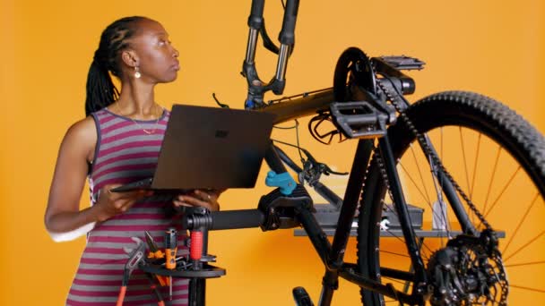 Técnico Con Portátil Mano Analizando Bicicleta Rota Sobre Fondo Del — Vídeo de stock