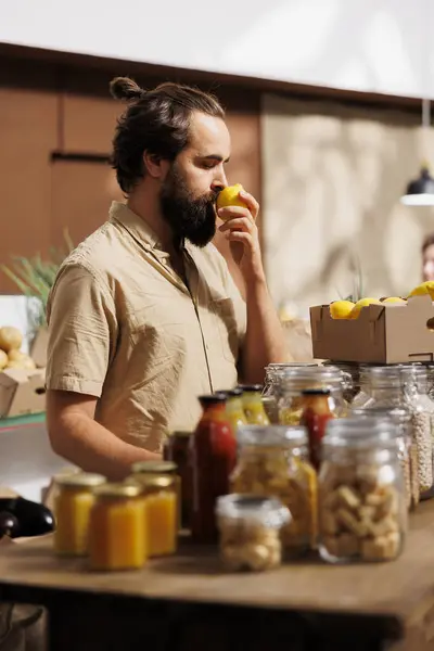 在零废品商店里的人闻到柠檬的味道 确保它们是手工采摘的 是农场种植的 环保生客彻底检查本地超级市场的食物是免费的 — 图库照片