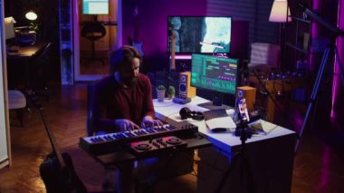 Sanatçı ev stüdyosundan piyano dersleri veriyor, özel ders kaydediyor ve Midi kontrol sentezleyicisini çalıyor. Eğitmen elektronik klavye notalarını ve müzik endüstrisini açıklıyor. Kamera B.