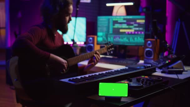 Songwriter Spielt Akustikgitarre Heimstudio Mit Greenscreen Display Das Auf Smartphone — Stockvideo