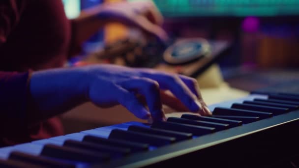 ピアノのキーボードを演奏し ソフトウェアで音を録音し オーディオトラック楽器やボーカルをキャプチャする熟練したアーティスト プロデューサーは ポストプロダクションでコンソールを混合して曲を作成します カメラ — ストック動画