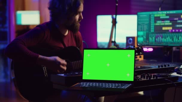 기타리스트는 노트북에 스크린 자신의 악기를 스튜디오에서 기타를 연주하는 새로운 문자열을 — 비디오