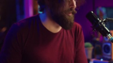 Müzik yapımcısı şarkısını piyano klavyesinde çalıyor ve mikrofonda şarkı söylüyor. Karıştırma konsolunda düzenleme yapmak için ses kaydı yapıyor. Besteci ev stüdyosunda synthesizer ile çalışıyor. Kamera A.