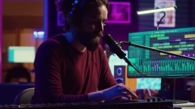 Şarkı sözü yazarı mikrofonlu yeni bir şarkı kaydediyor ve Midi kumandalı, ev stüdyosunda piyano tuşları çalıyor. Modern elektronik klavye ve aletlerle müzik üreten yetenekli bir sanatçı. Kamera A.