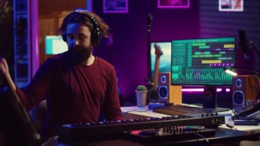 Gitar ve klavye çalan söz yazarı müzisyen, yeni modern şarkılar üretmek için akustiği monitörlerle kaydediyordu. Dengeleyici ve daw yazılımı. Kamera A.