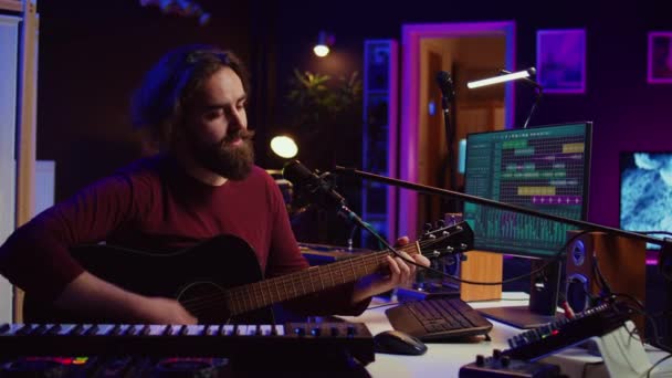 작곡가는 스튜디오에서 기타를 연주하며 마이크로폰을 사용하여 코드를 부릅니다 오디오 엔지니어는 — 비디오