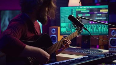 Stüdyoda akustik gitarıyla şarkı besteleyen sanatçı notalar kaydediyor ve mikrofonda şarkı söylüyor. Ses mühendisi, melodilerini stereo ekipmanlarla karıştırıp ustalaştırıyor. Kamera A.