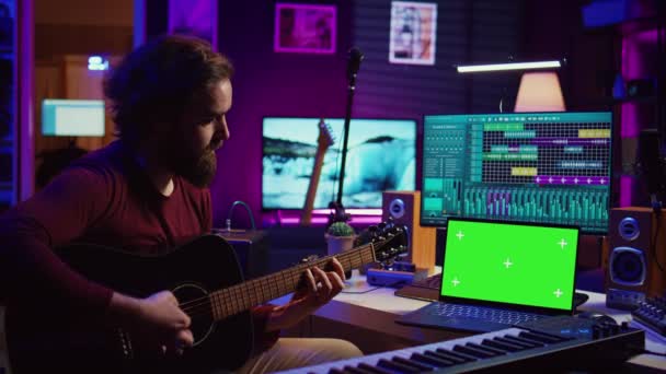 音乐学者的初学者通过观看教程和在线课程来学习声乐吉他 笔记本电脑显示出绿色屏幕的色调 艺术家在家里的工作室里练习吉他技巧 摄像头B — 图库视频影像