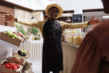 Şapkası ve önlüğü olan dost canlısı bir Afrikalı Amerikalı 'ya ait modern bir çevre dostu süpermarket. Çeşitli taze ve sağlıklı ürünler satarak müşterileri açık kollarla alışverişe davet ediyor..