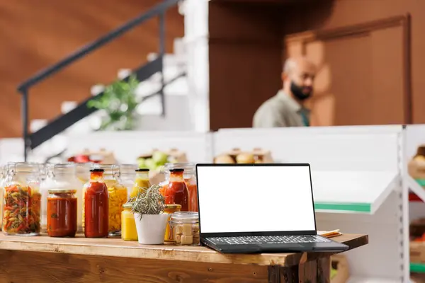 新鮮な果物と野菜で満たされたバイオショップで白い画面を表示するワイヤレスコンピュータ 無駄な店の単離された染色体モックアップテンプレートを示すデジタルラップトップ — ストック写真