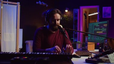 Şarkı sözü yazarı mikrofonlu yeni bir şarkı kaydediyor ve Midi kumandalı, ev stüdyosunda piyano tuşları çalıyor. Modern elektronik klavye ve aletlerle müzik üreten yetenekli bir sanatçı. Kamera B.