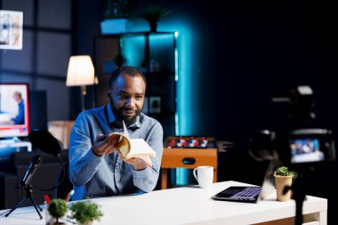 Afrikalı Amerikalı içerik yaratıcısı çevrimiçi yayın kanalı aboneleri için edebiyat eleştirisi yapıyor. İnternet şovu sunucusu yeni kitap yayınlama önemi hakkında yorum yapıyor, okuyucular için video denemesi yapıyor