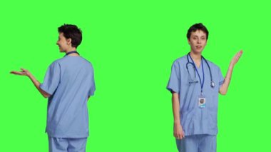 Tıbbi asistan bir kenara bir şey gösteriyor ve internet reklamı yapıyor, yeşil perde arkaplanına karşı reklam yapıyor. Önlüklü genç hemşire sol ya da sağ tarafta bir şey gösteriyor. Kamera B.