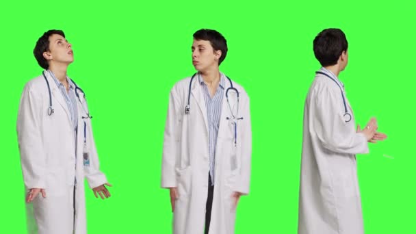 一般開業医は 患者が検査の予定に出席するのを待っており 緑色の背景に不満を感じています 白いコートを着た女性医師は 自信を持った医者を待っています カメラ — ストック動画