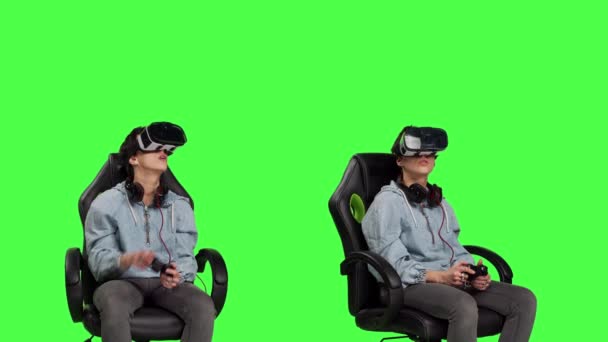 スタジオで仮想現実ヘッドセットを使用してビデオゲームをプレイする女性は 緑色の背景に対してサイバースペース3Dゲームトーナメントを楽しんでいます ガーメガネで楽しんでいました カメラ — ストック動画