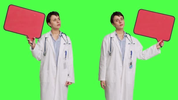 스튜디오에서 빨간색 기호를 스크린 배경에 마분지 아이콘을 보여주는 의사는 배너로 — 비디오