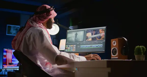 アラビアのカラーリストのフリーランサーがヘッドフォンを着用しながらプロジェクトを編集し ビデオを一緒にステッチし 画像やサウンドで作業します Pcワークステーションで映画を処理する人材を採用 — ストック写真