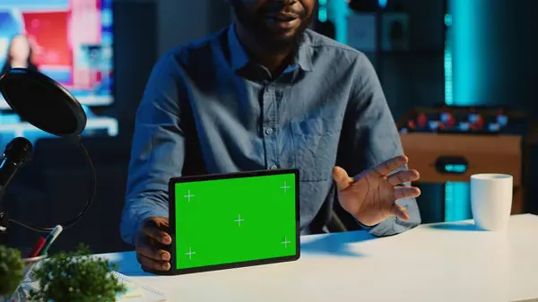 Content creator films chroma key tablet video review for tech enthusiasts using recording gadgets. Viral online star hosts social media internet show, unboxing green screen digital device, close up