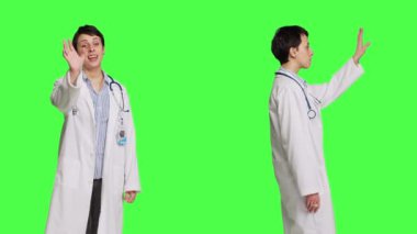 Pratisyen hekim hastaları karşılıyor ve onları muayene randevularında hastalara daha yakın olmaları için davet ediyor. Doktor insanlara el sallıyor ve ona yaklaşmalarını istiyor. Kamera B.