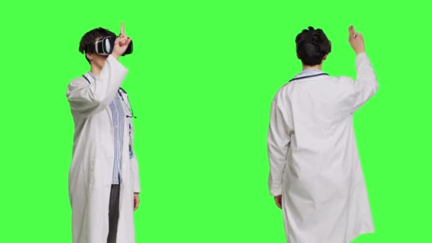Žena Medik Pracuje Virtuální Realitou Sluchátka Studiu Stojí Zeleném Pozadí — Stock video