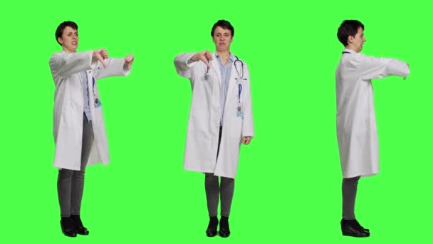 Missnöjd Läkare Visar Tummen Ner Symbol Mot Grön Bakgrund Uttrycker — Stockvideo
