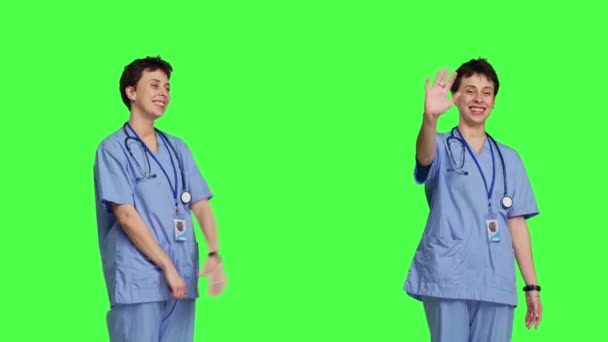 Neşeli Bir Tıbbi Asistanın Hastaları Gülümseyerek Selamlaması Sallaması Stüdyoda Yeşil — Stok video