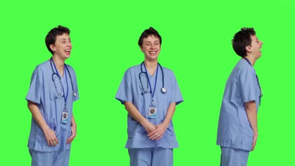 Веселая Улыбающаяся Медицинская Ассистентка Стоит Фоне Зеленого Экрана Чувствуя Себя — стоковое видео