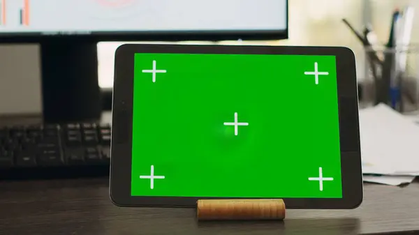 在商务合作空间的平板电脑上设置有绿色显示屏的空桌子 在现代小玩艺儿的显示屏上设置有独立的复制空间 工作站 其设备显示铬键模拟屏幕 — 图库照片