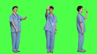 Kadın hemşire selam veriyor ve insanları daha yakına gelmeye davet ediyor, yeşil ekrana karşı sağlık muayenesi için hastaları çağırıyor. Tıbbi asistanlar insanları selamlıyor ve gelmelerini istiyor. Kamera A.