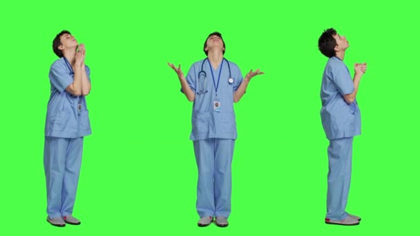 病院の看護師は 緑色の背景に祈り イエス キリストに祈り キリスト教と霊性に希望を持って神を崇拝しています 瞑想をしている医療アシスタント カメラ — ストック動画