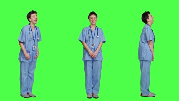 Gülümseyen Neşeli Bir Tıbbi Asistan Yeşil Ekran Arkaplanına Karşı Duruyor — Stok video