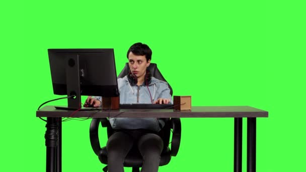 Junge Erwachsene Spielen Videospiele Computer Schreibtisch Vor Greenscreen Hintergrund Und — Stockvideo