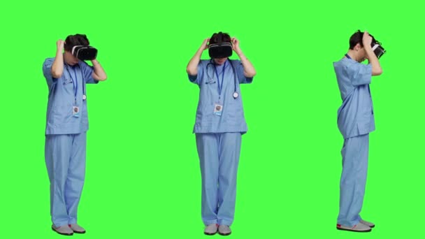 医疗助理在绿屏背景下使用虚拟现实眼镜 在Vr耳机上使用交互式3D视觉进行检查 年轻的护士使用现代小玩意 相机A — 图库视频影像