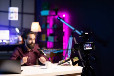 ASMR sanatçısı stres karşıtı video yapmak için stüdyoda kaliteli mikrofon ve kayıt kamerası kullanıyor. Fısıltı sesleri çıkarıyor. Profesyonel mikrofon ve yüksek teknoloji ürünü ekipman kullanan bir adam.