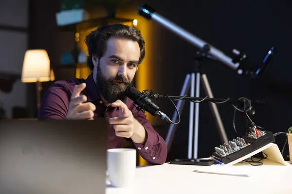 stock image Content creator in home studio doing cool hand gesturing towards camera during live broadcast on online streaming platforms. Entertainer pointing fingers, captivating audience