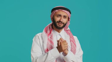 Umut dolu Müslüman bir adam bir şey diliyor ve istiyor, bir duada el ele tutuşuyor ve inançlı. Orta Doğulu yetişkin çaresiz ve yardım arıyor, stüdyoda lütfen diyor..