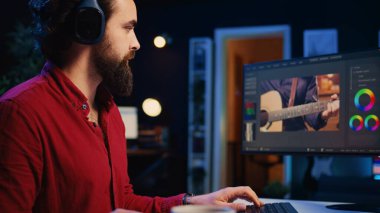 Video editörü çekimlere ses efektleri ekliyor, post-prodüksiyon stüdyosunda çalışıyor, çekim yapıyor. Düzenleme araçları kullanılarak ses kalitesini test etmek ve geliştirmek için kulaklık kullanan kameraman
