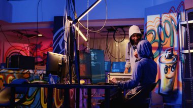 Hacker gizli bir yeraltı üssüne kurbandan elde edilen verileri kendi geliştirdikleri fidye yazılımını yüklemek için oyuna getirdikten sonra SSD ile geliyor. Erkekler suç planlarından memnun.