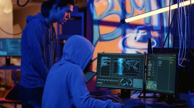 Hackers in dark room trying to steal valuable data by targeting governmental websites with weak security. Evil computer scientists doing cyber attacks to gain access to sensitive info clipart
