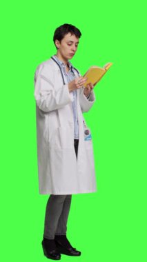Medikal uzman, sektördeki tıbbi uzmanlığını geliştirmek için sağlık edebiyatı kitabı okuyor ve yeşil perde arkaplanına karşı çıkıyor. Beyaz önlüklü zeki doktor dersten zevk alıyor.