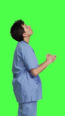 Profil hastanesi hemşiresi Tanrı 'ya dua ederek yeşil perdeye karşı, İsa Mesih' e dua ederek ve Hıristiyanlık ve maneviyattan umutla dua ederek ibadet ediyor. Meditasyon yapan bir tıp asistanı. Kamera B.