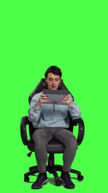 Öndeki bakış Mutlu Oyuncu onun başarısını online oyun turnuvasıyla kutluyor, tablette yeşil perde arkaplanına karşı atış yarışması yapıyor. Kendine güveni tam bir kadın kazanmak istiyor. Kamera.