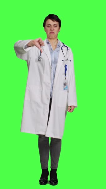 Widok Przodu Niezadowolony Lekarz Pokazując Kciuki Dół Symbol Zielonym Tle — Wideo stockowe