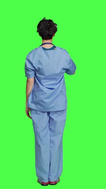 バックビューのヘッドセットを使用して患者の診断を調べる健康専門家は 緑色の背景に立っています 看護師は人工知能仮想現実メガネ 3次元で働いています — ストック動画