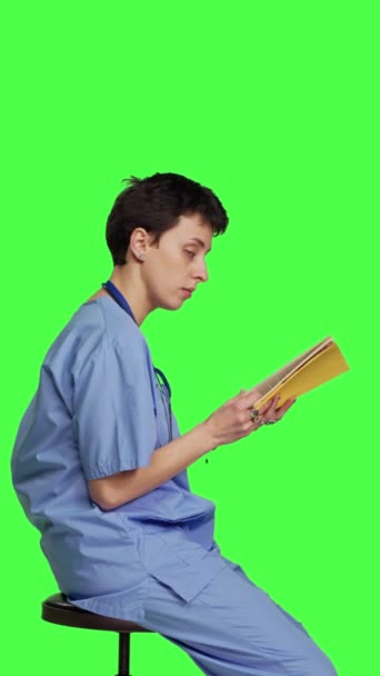 Профиль Молодая Медсестра Готовится Экзамену Врача Читая Книгу Студии Сидя — стоковое видео