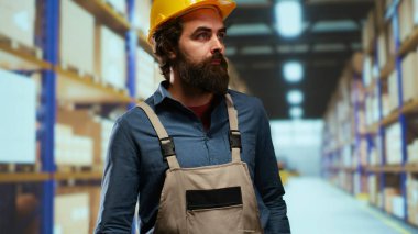 Ambalaj operatörü endüstriyel depodaki paletleri sayıyor, üretimi optimize etmek için lojistik üzerinde çalışıyor. Depo işçisi, üretilen ürün ve malzemelerin dağıtımıyla çalışır..