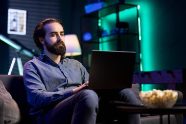 Adam rahat bir dairede oturmuş dizüstü bilgisayarda yazı yazıyor ve patlamış mısırla televizyon izliyor. Arka planda film oynatarak dizüstü bilgisayardaki görevleri çözen telesekreter