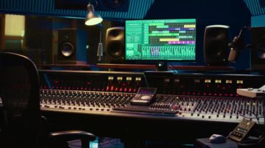 Müzik kayıt endüstrisinde kullanılan boş kontrol odası profesyonel stüdyo, konsolu karıştırma ve prodüksiyon ekipmanları. Daw yazılımı, solgunlaştırıcıları ve ses düzenleme araçlarıyla ses geçirmez alan.