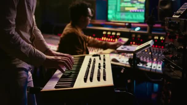 音乐家在专业录音室的控制室里弹奏钢琴 用电子键盘音符创造声音 音响工程师确实混合和掌握了文件 摄像头B — 图库视频影像